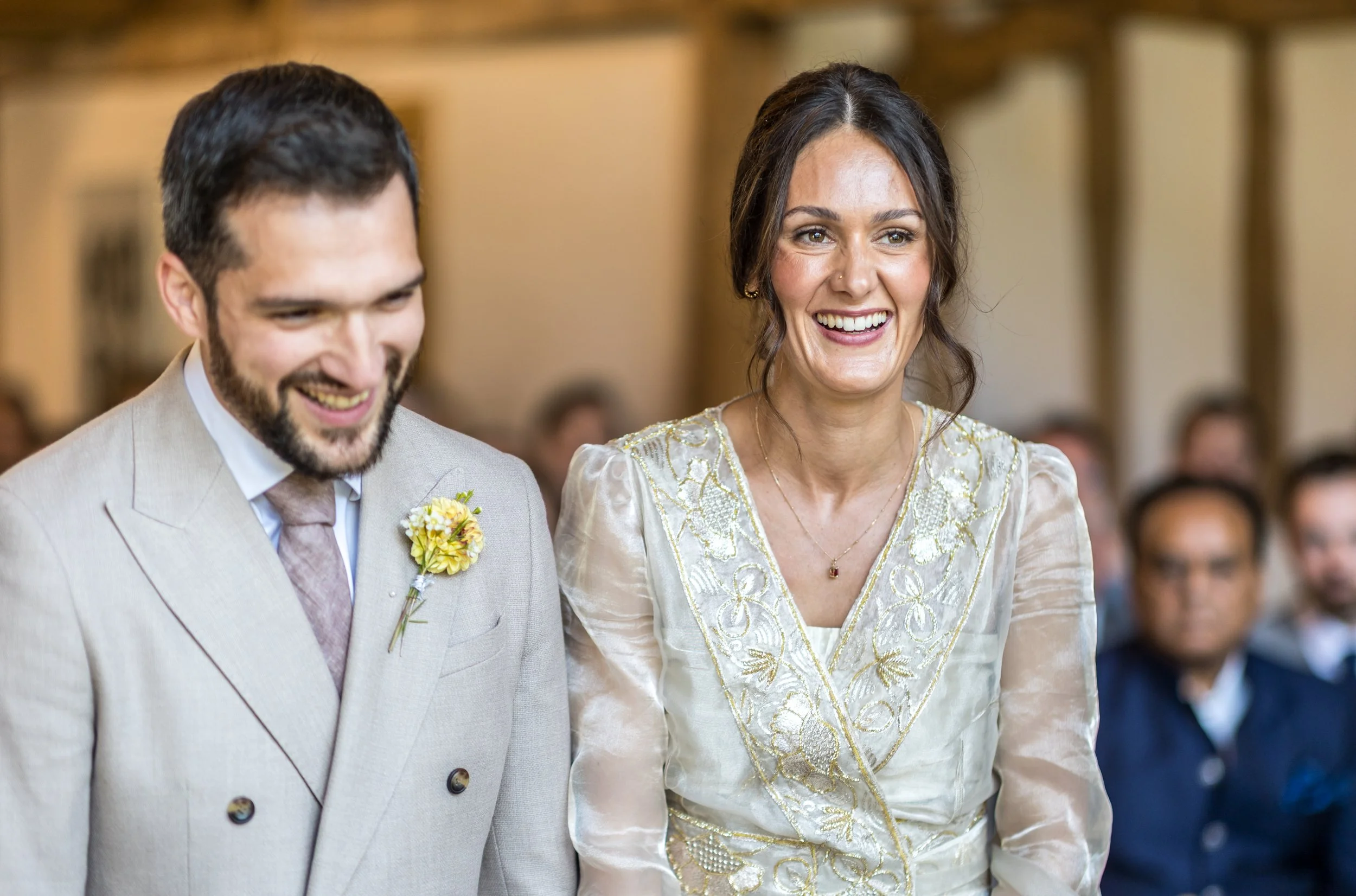 A bride and groom laughing during their wedding ceremony at Blake Hall in Essex.