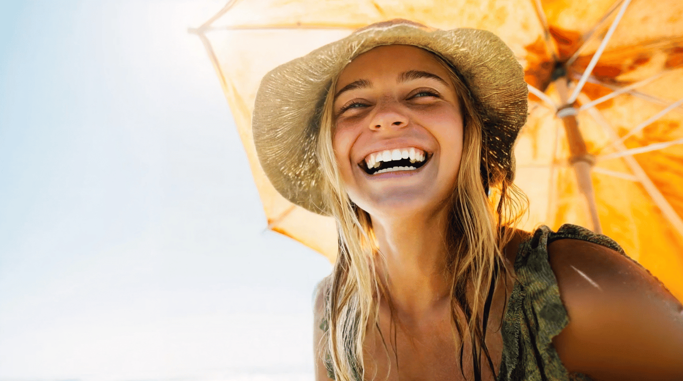 Laughing happy Woman with Sun Hat at Beach