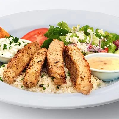 An image of the grilled chicken feast showing strips of tender chicken breast atop a bed of basmati rice with a side of greek salad