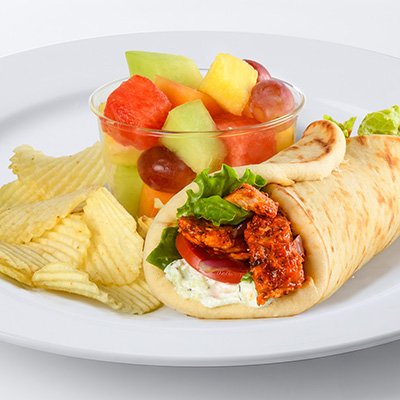 A photo of a spicy harissa chicken gyro with a side of potato chips and fresh cut fruit