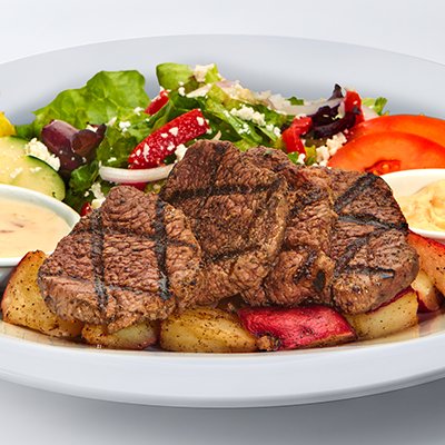 an image of the grilled beef feast showing grilled medallions of beef on top of roasted red potatoes with a side of greek salad