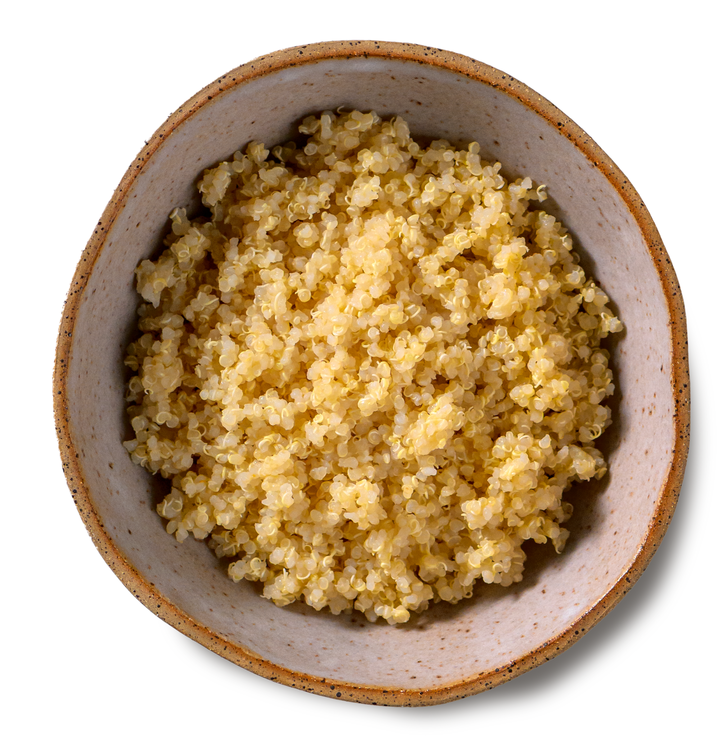 An overhead photo of a rustic, handmade pottery bowl filled with tender grains of cooked quinoa
