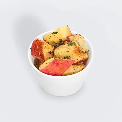 a photo of a small white bolw filled with roasted red potatoes