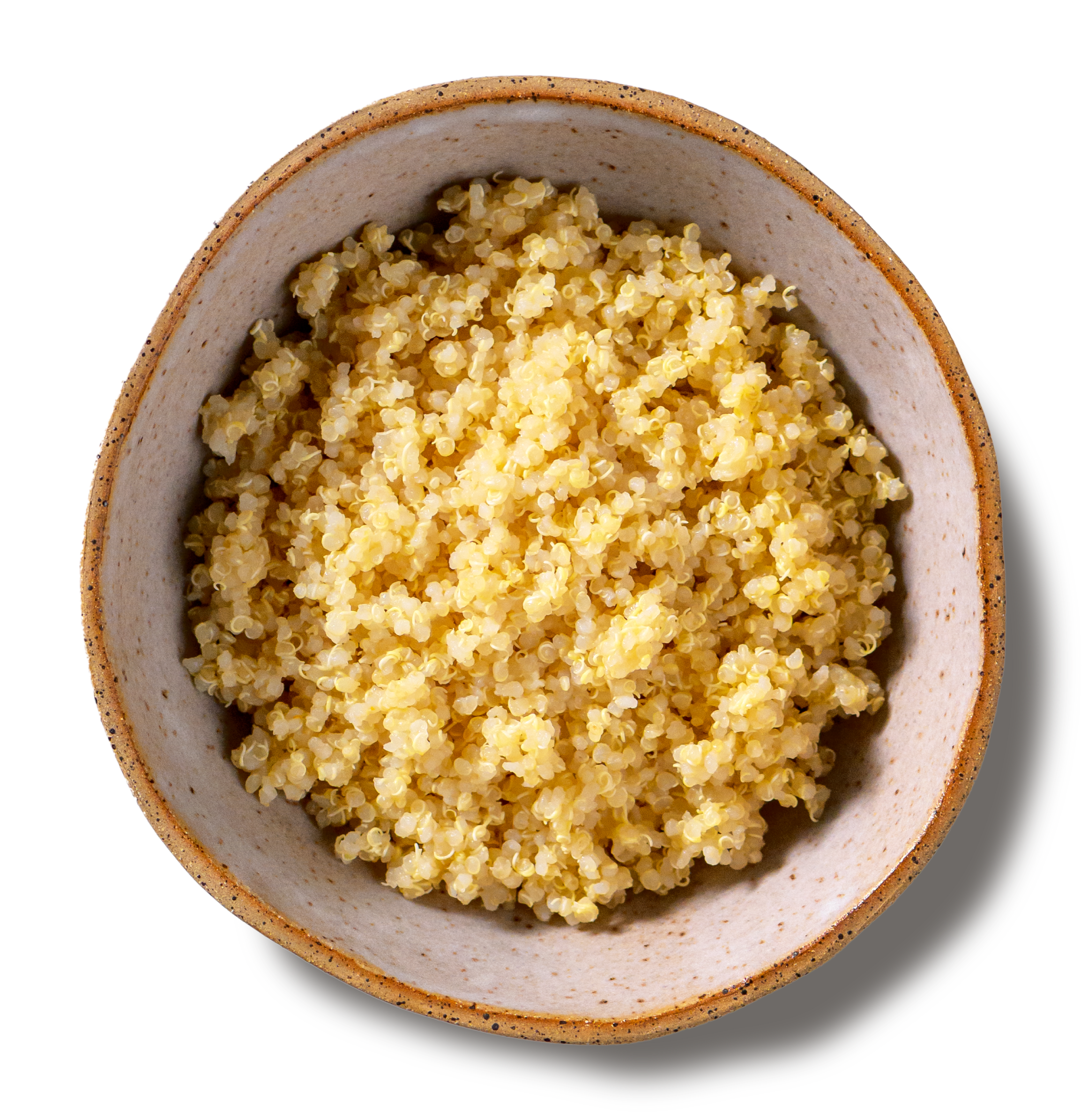 An overhead photo of a rustic, handmade pottery bowl filled with tender grains of cooked quinoa