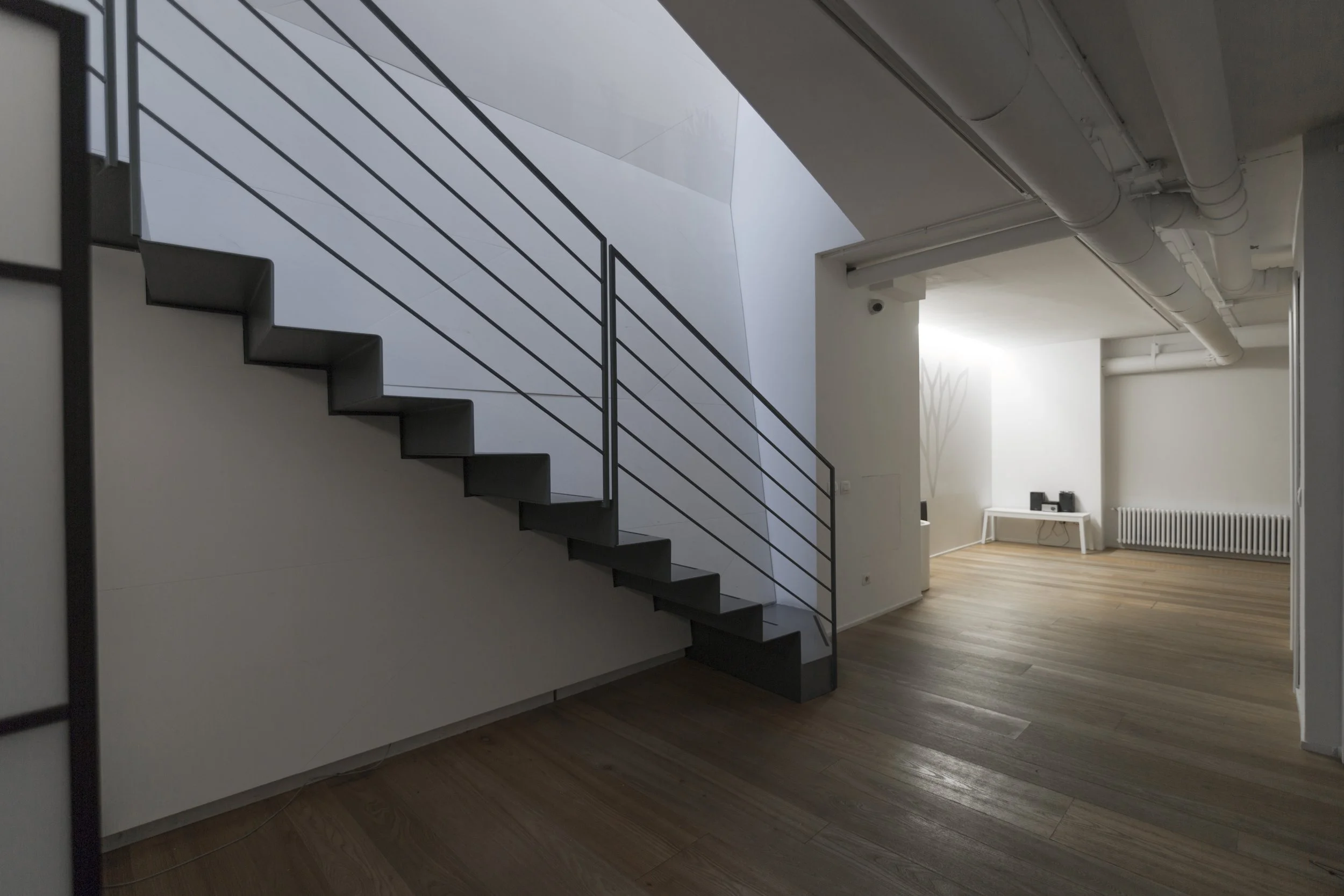 Sala interrata con pavimento in legno naturale, atmosfera minimal e silenziosa, ideale per pratiche di gruppo, meditazione e workshop.