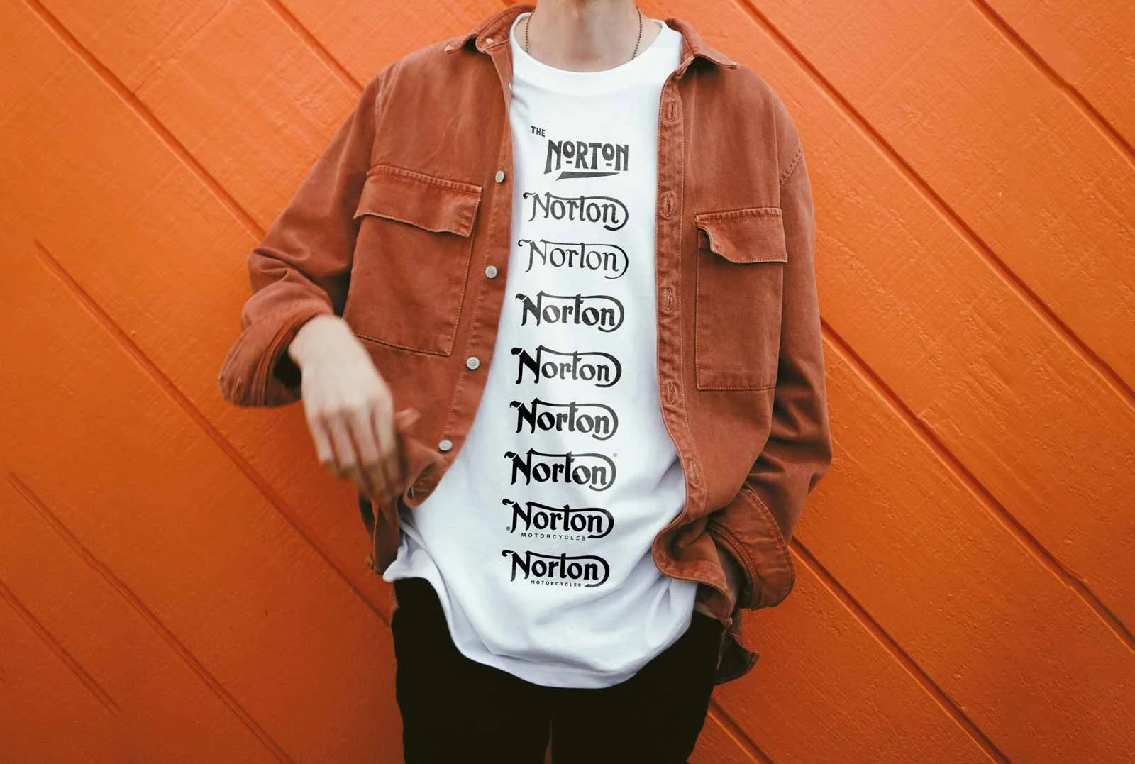 A person wears a white t-shirt with multiple "Norton" logos stacked vertically.
