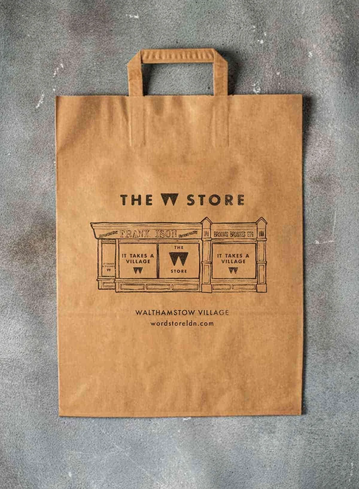 Brown paper shopping bag with "The W Store" logo and illustration of a storefront.