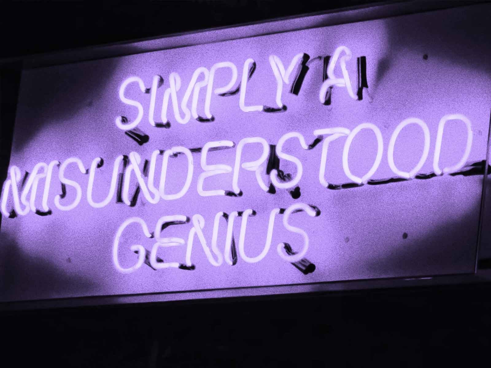 Purple neon sign reads "SIMPLY A MISUNDERSTOOD GENIUS".