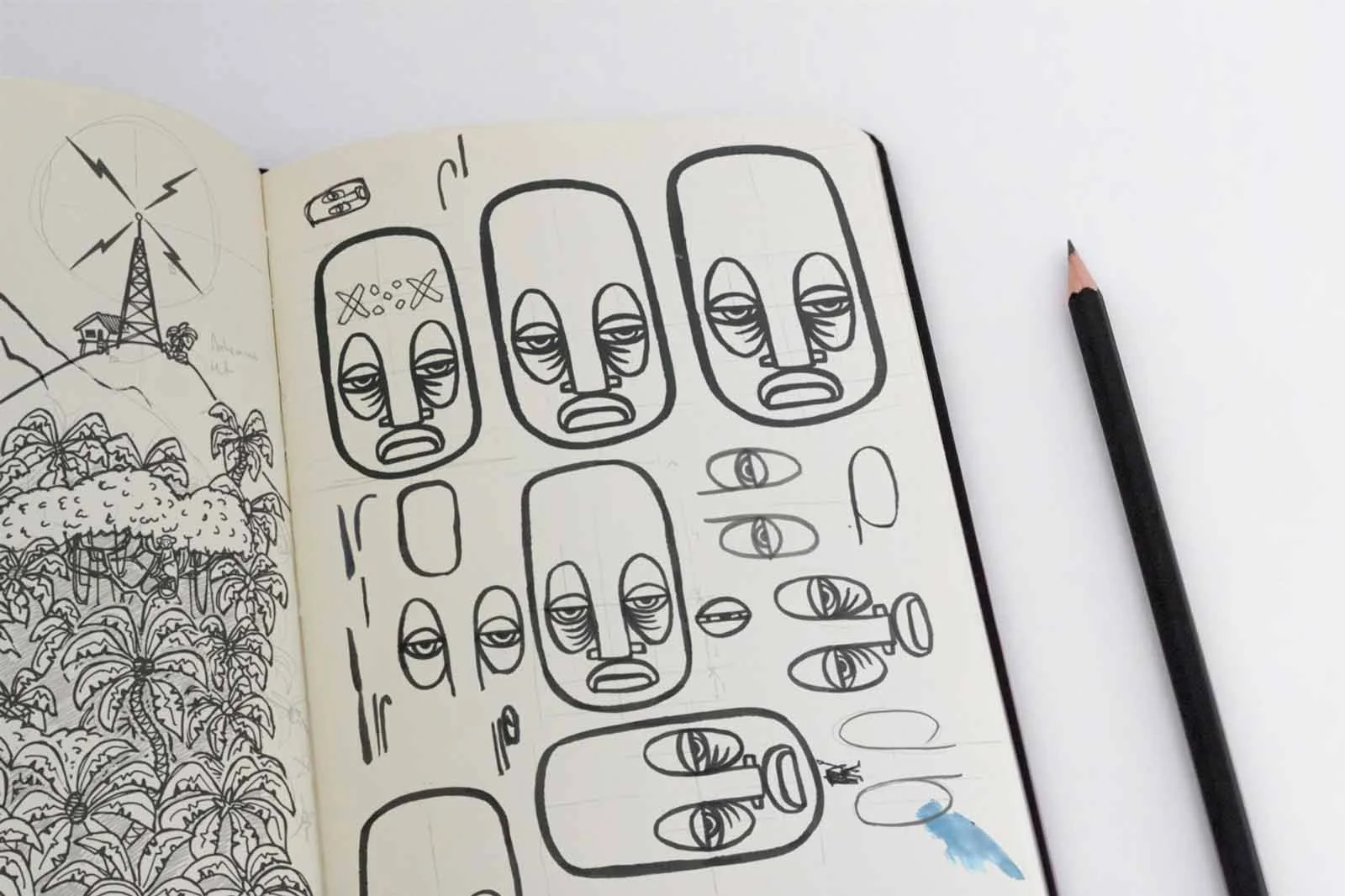 A sketchbook page displays doodles of faces and a landscape, with a pencil to the right.