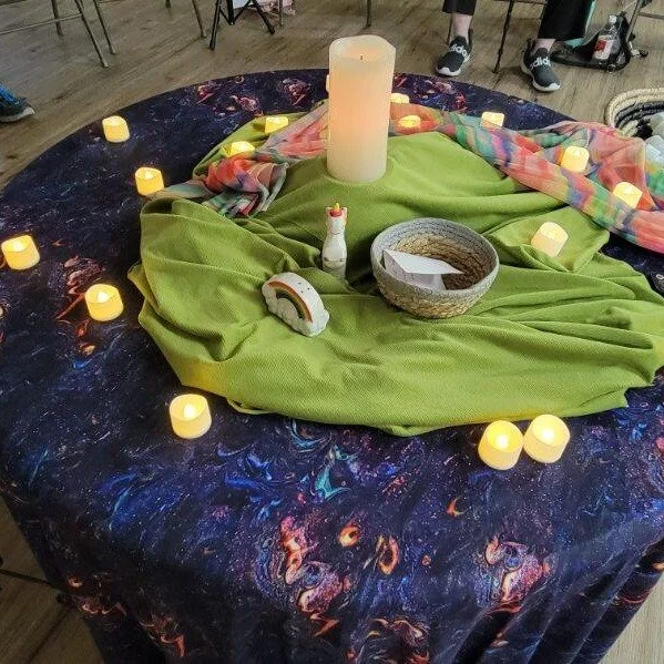 This is an image of the center table at The Circle Hbg gathering on September 21. The theme was Queerfully &amp; Wonderfully made. I chose the cloth that looks like the cosmos because we are made of the same elements as the stars. The green represent