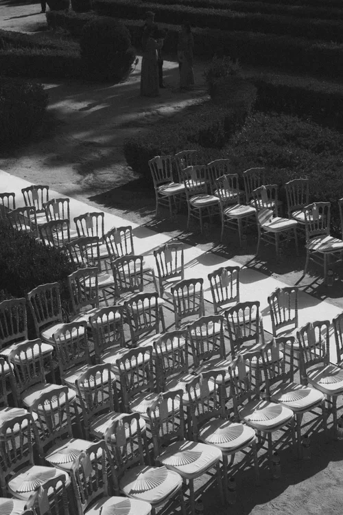 Aerial black and white view of elegant chiavari chairs set out in rows in a formal garden for an outdoor wedding ceremony in Malaga 