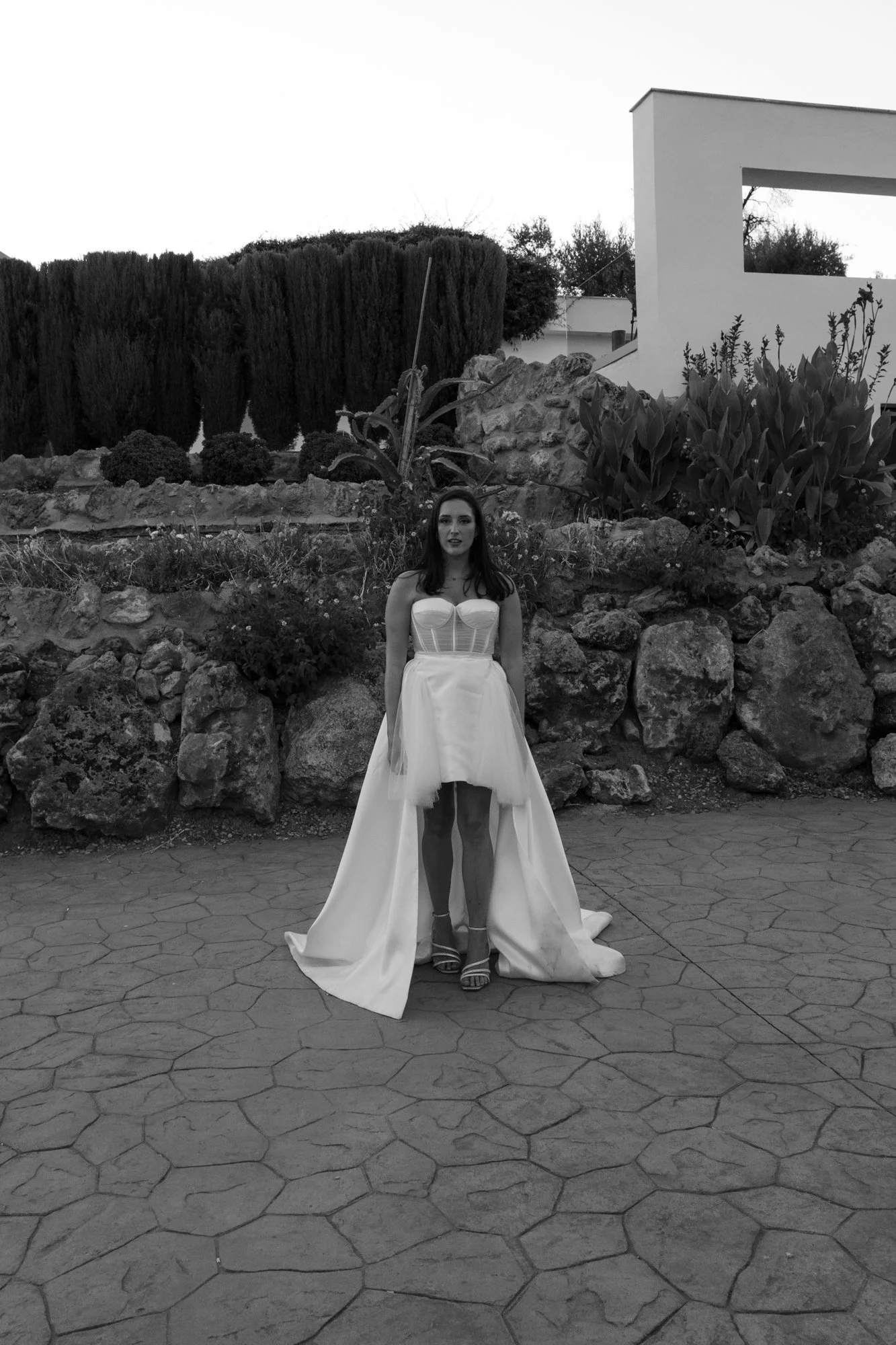 Bride in a strapless corset wedding dress with dramatic high-low skirt at an outdoor Spanish wedding venue in Malaga