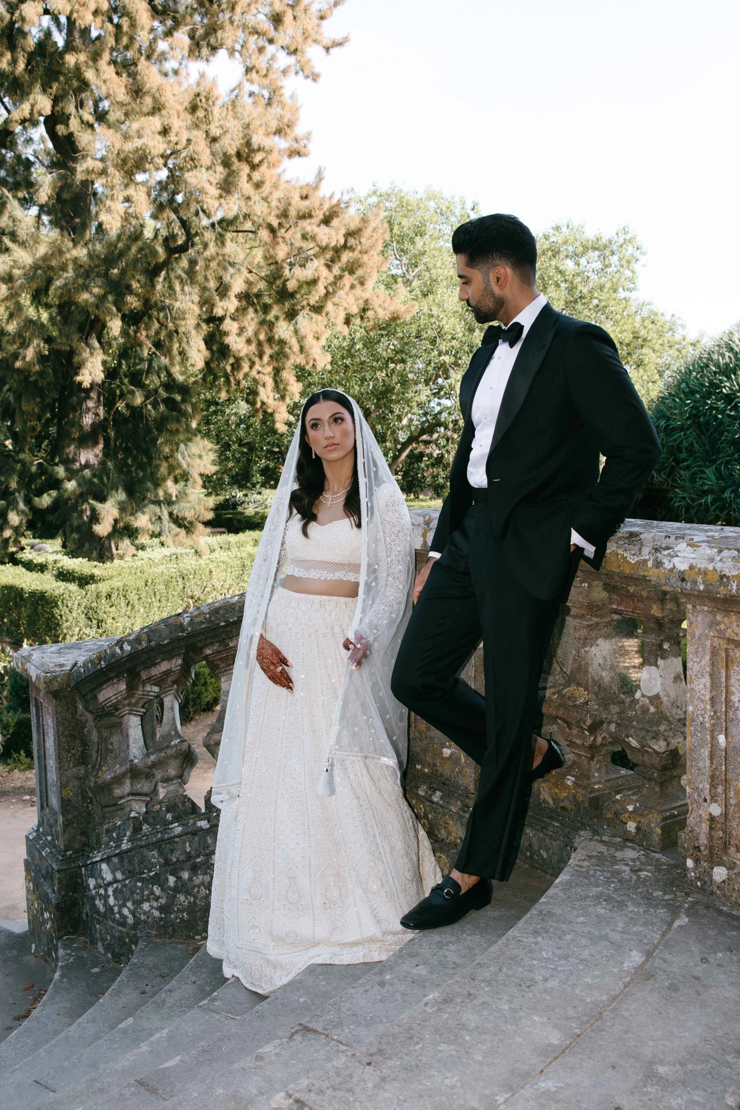Bride and groom posing on stone steps at luxury wedding venue in Marbella