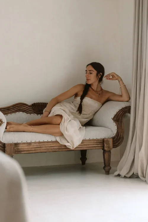 Bride lounging elegantly on an antique ornate sofa in a luxury Malaga wedding venue