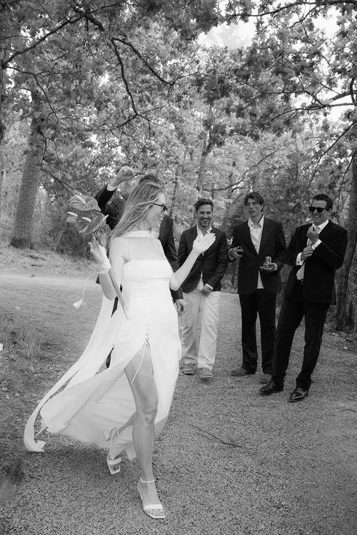 Bride laughing and dancing with male wedding guests in a pine forest setting, candid Marbella wedding reception 