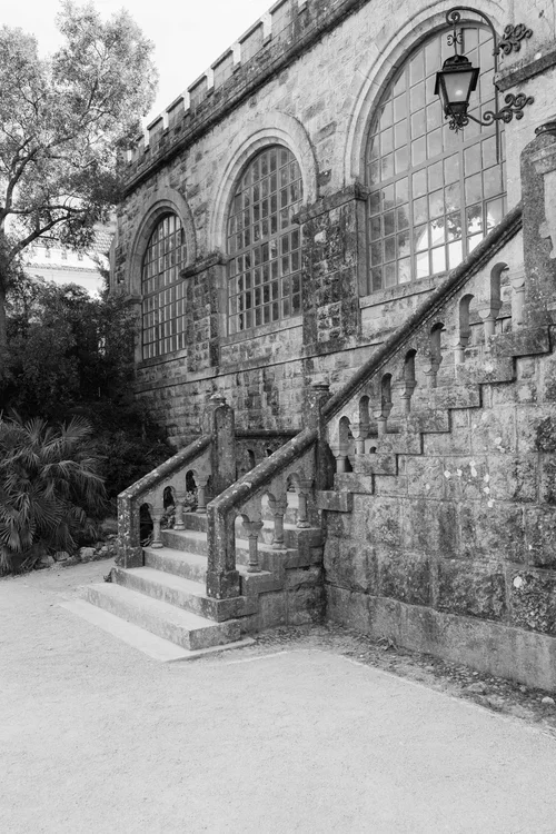 Ancient mossy stone steps and castle entrance with arched windows and ornate iron lantern at a historic Malaga wedding venue