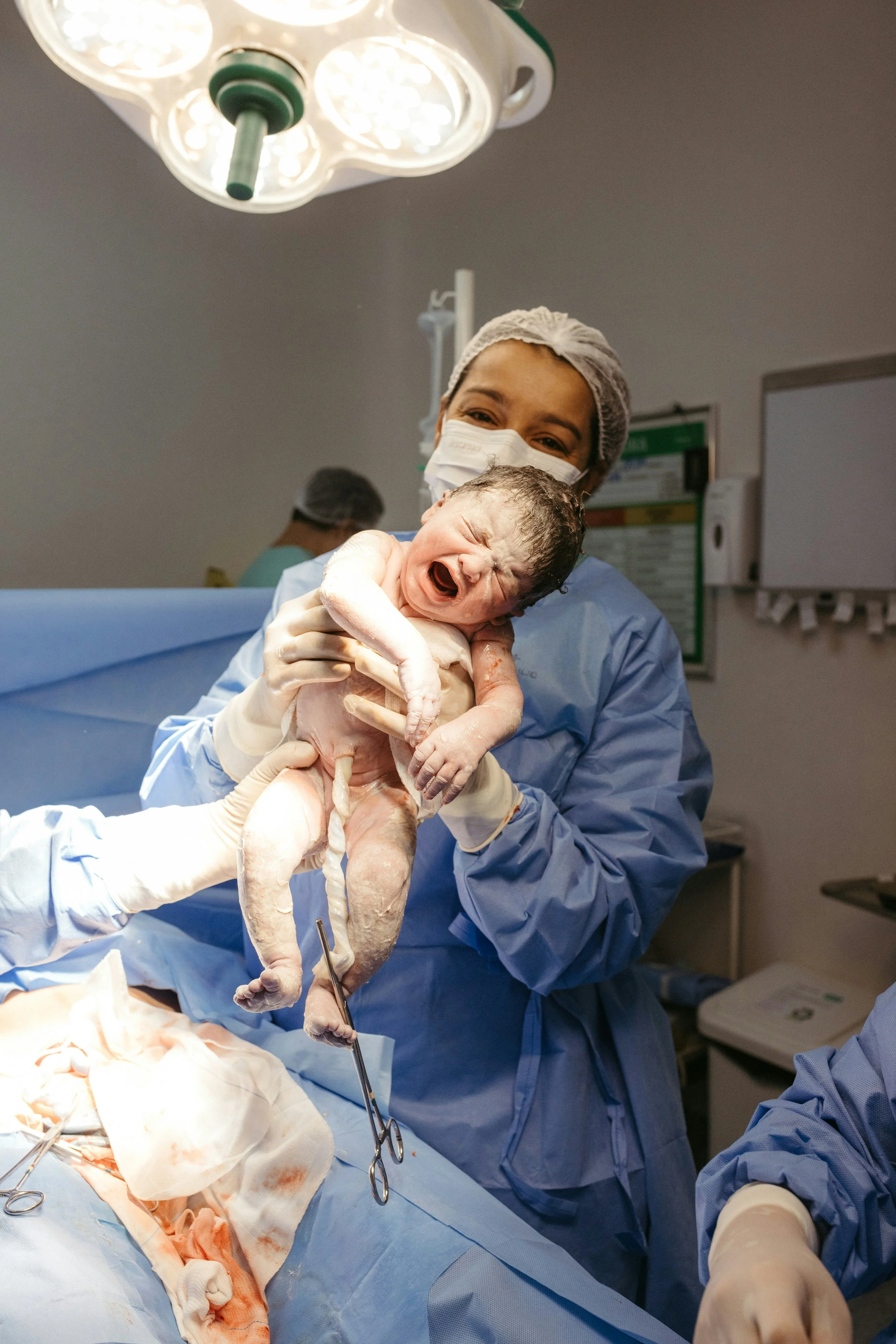 Doctor holding newborn immediately after c-section delivery