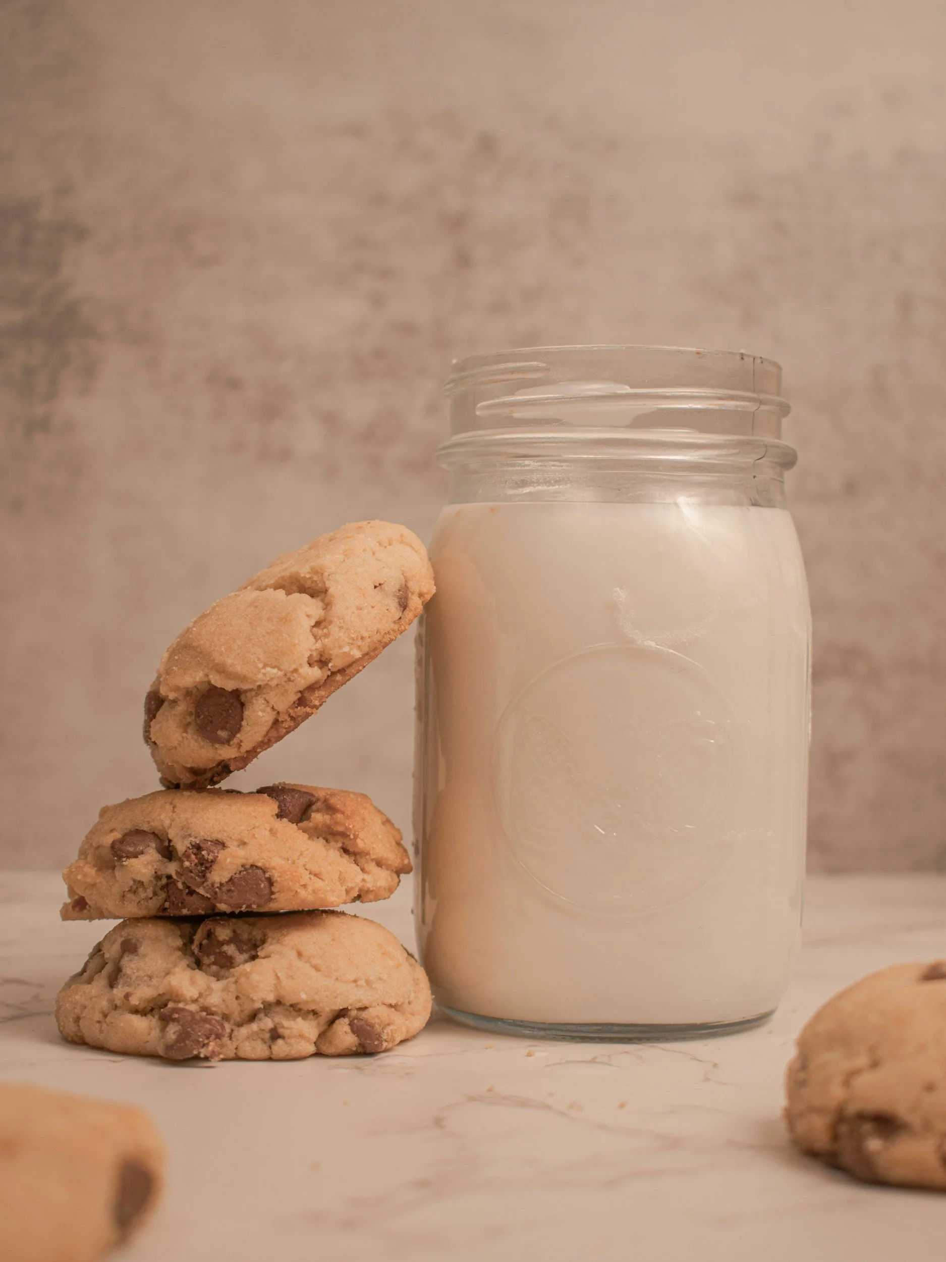 lactation cookies balanced up against mason jar of milk