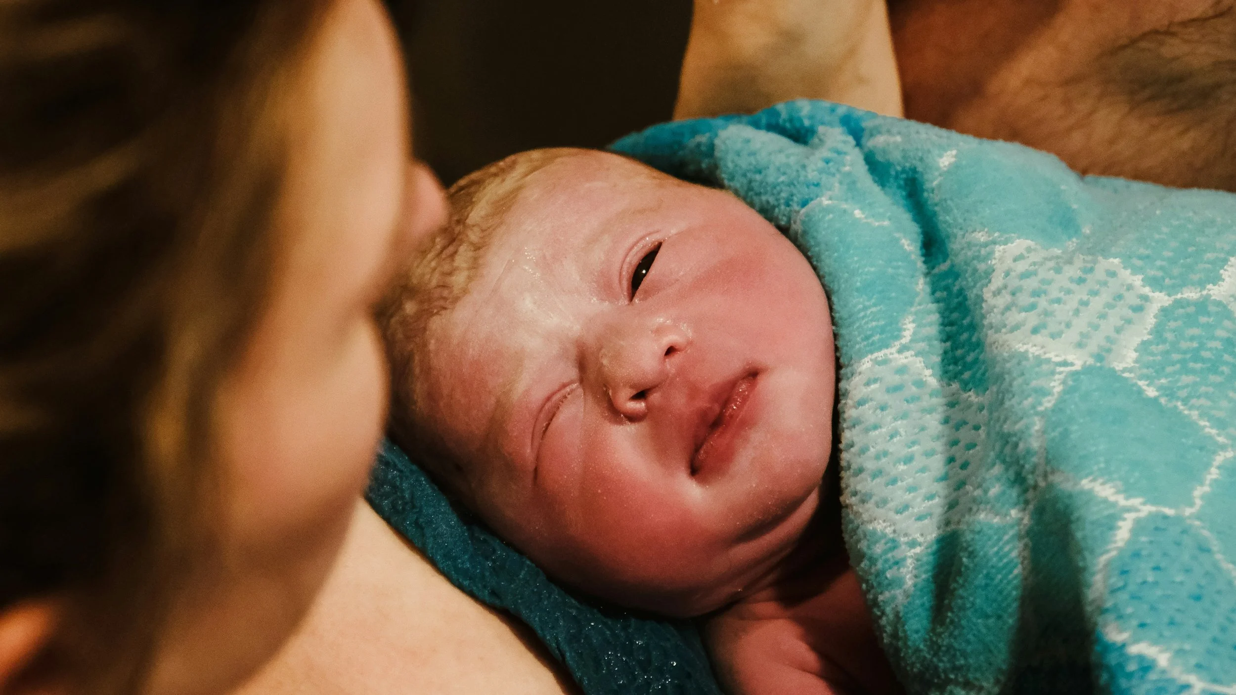 Newborn baby laying on mother during Milwaukee area home birth