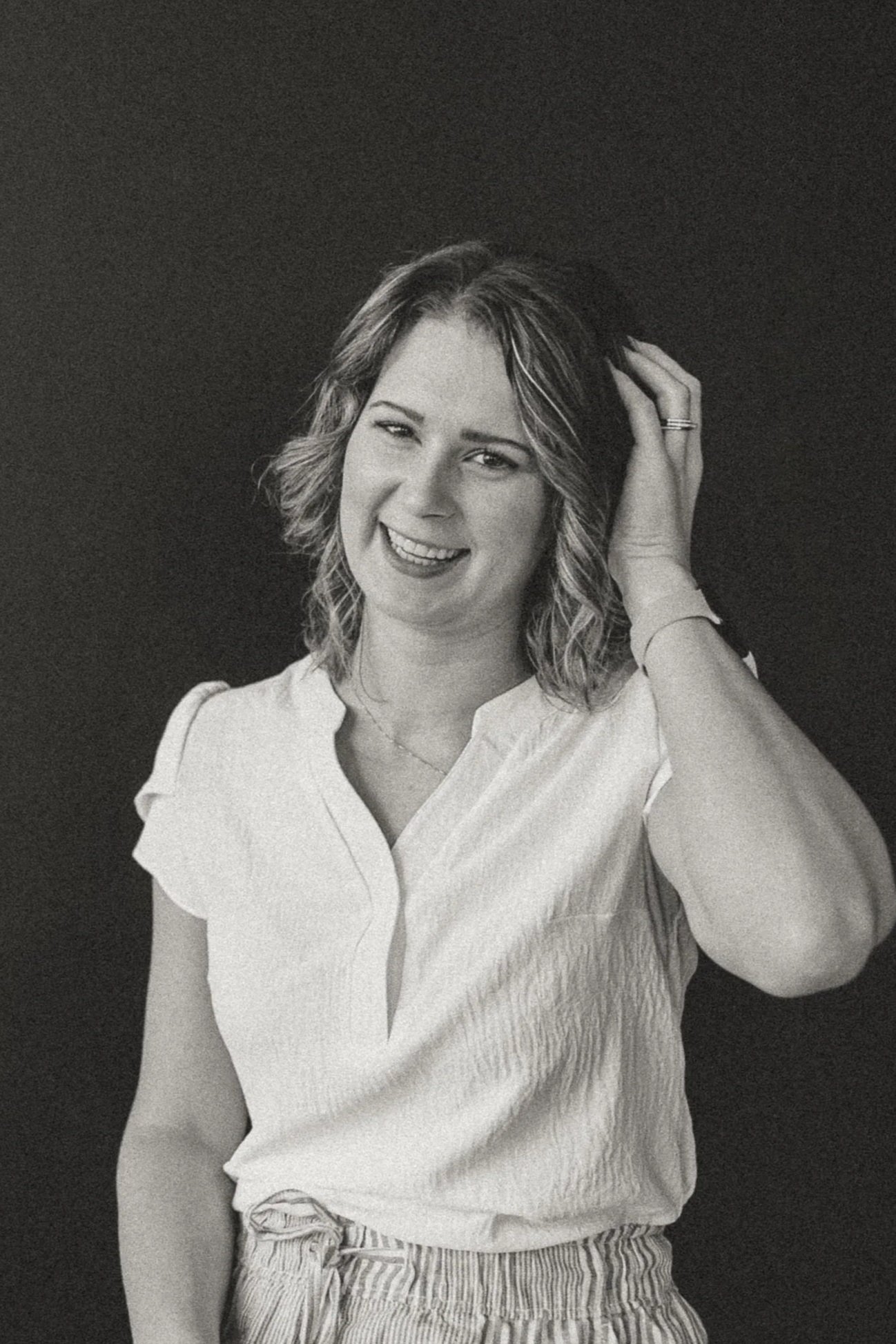 Beth Connors a home birth midwife in waukesha headshot photo touching hair