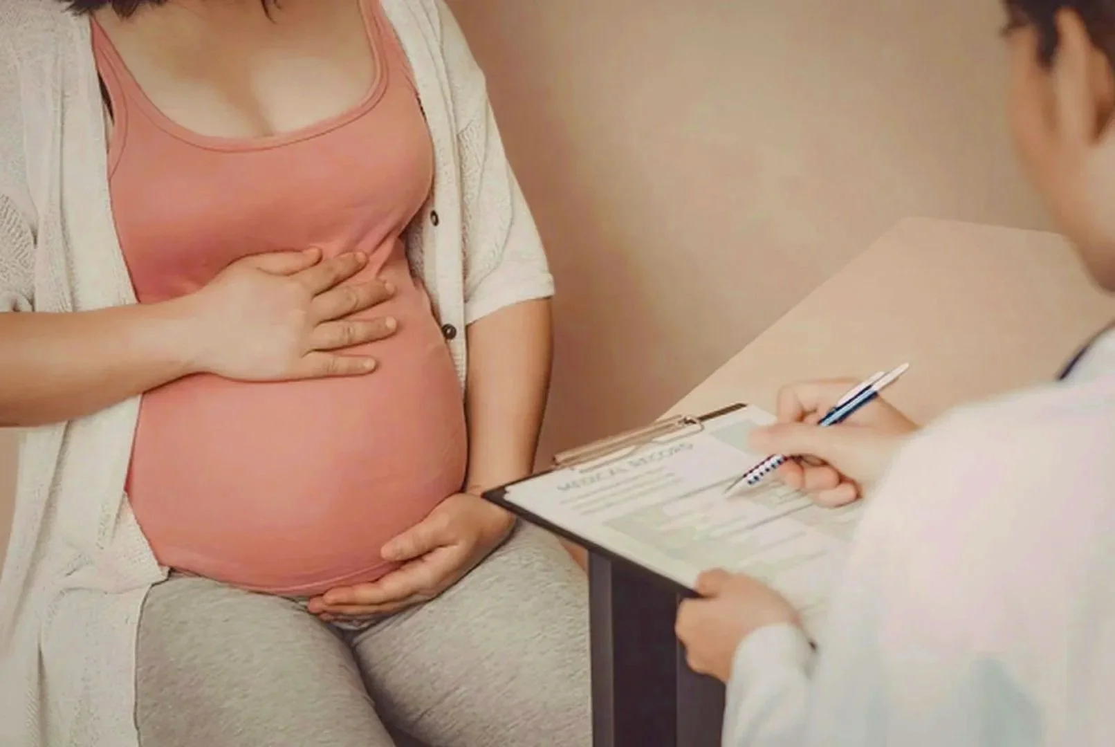 Pregnant woman reviewing information and birth preferences with provider about birth plan choices