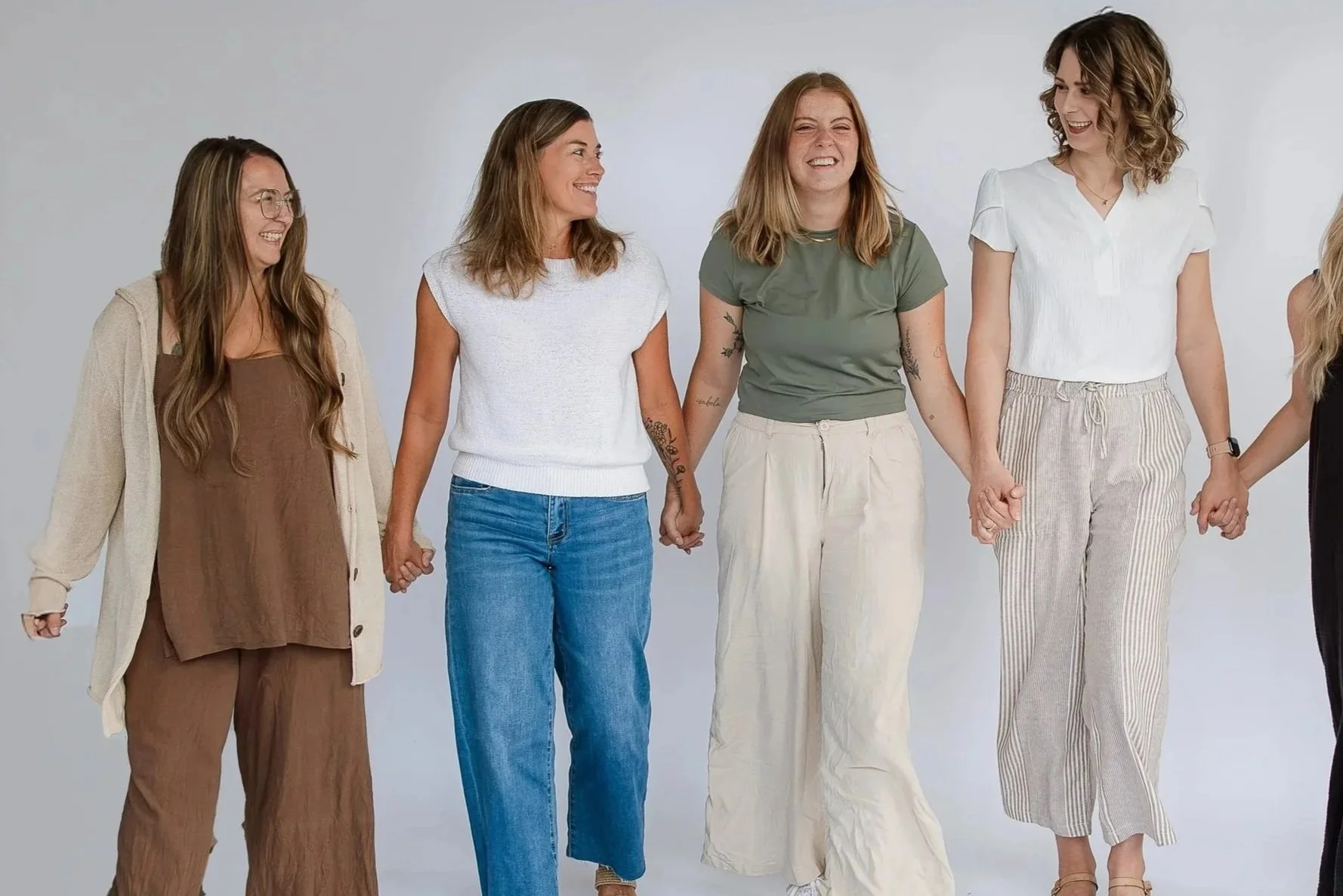 group of birth doulas in milwaukee holding hands and smiling at each other