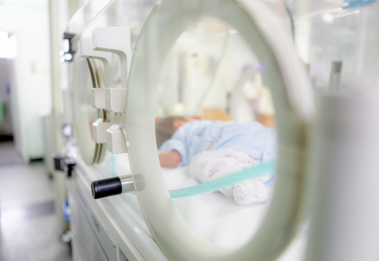Newborn in an isolette in the NICU