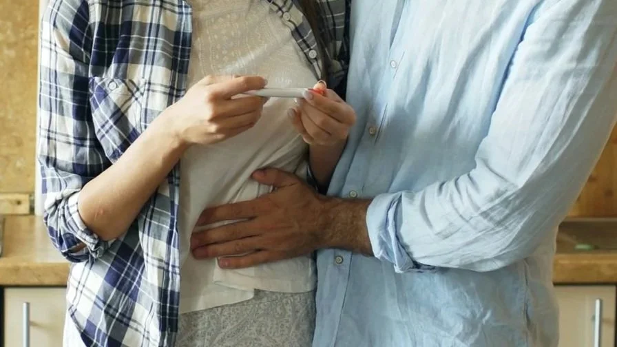 couple with positive pregnancy text awaiting first pregnancy appointment