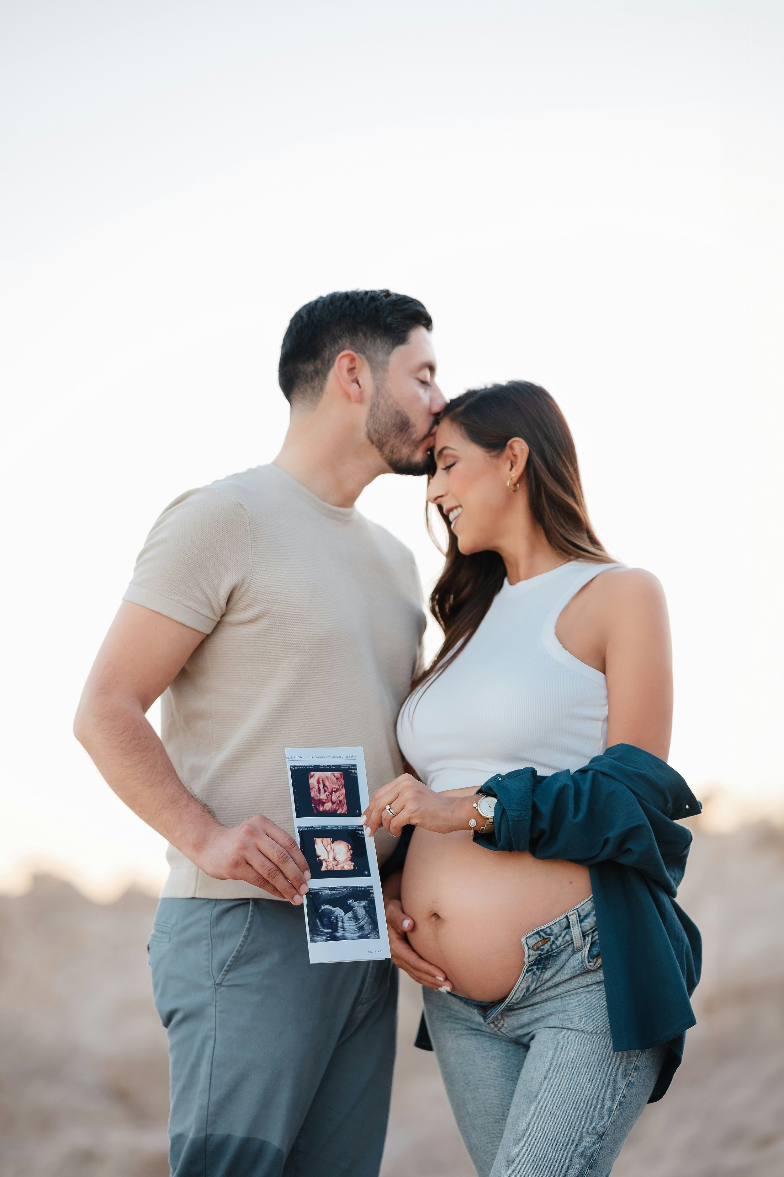 Mom and dad holding ultrasound from anatomy scan at 20 weeks pregnant.