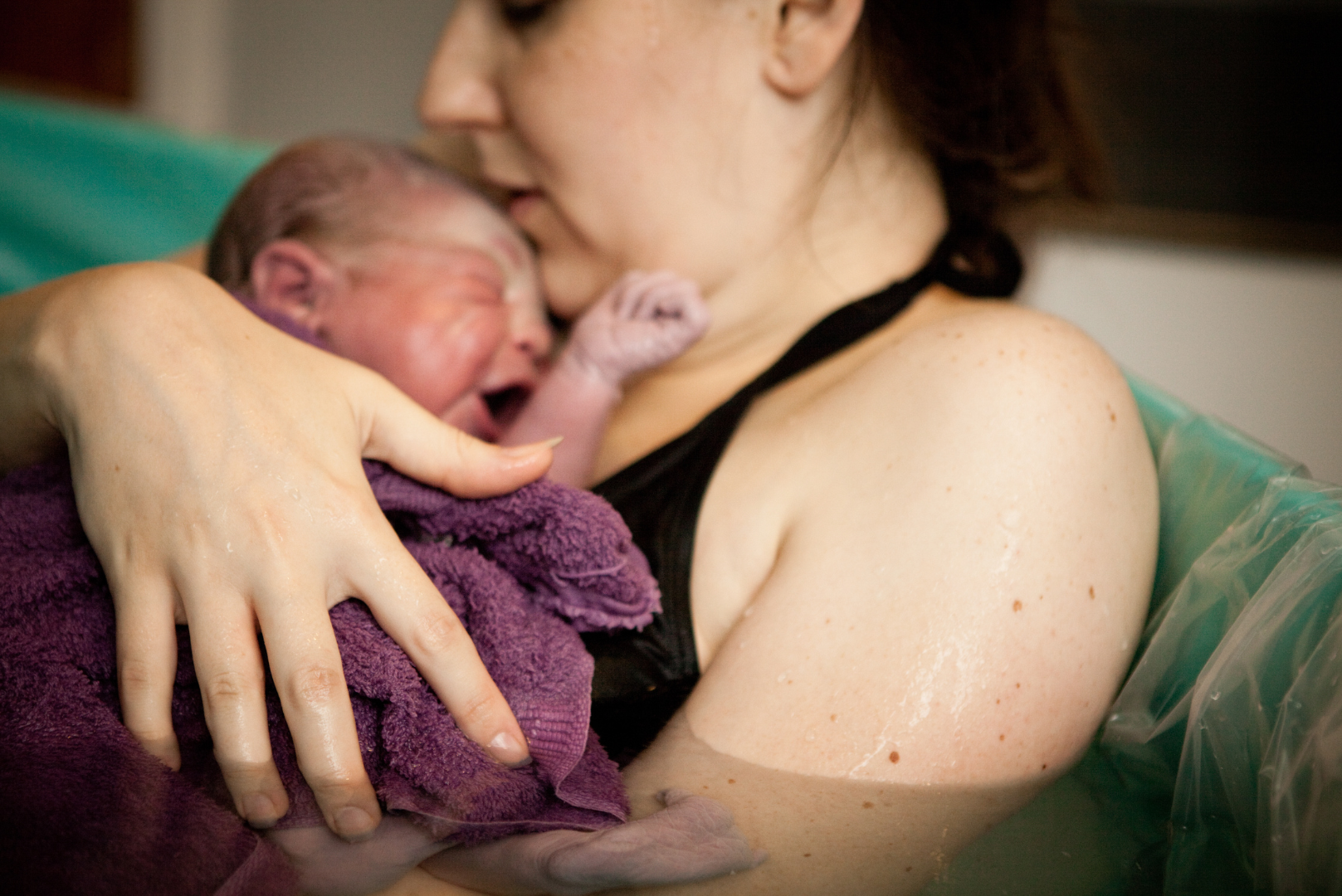 Mom holding newborn after home water birth