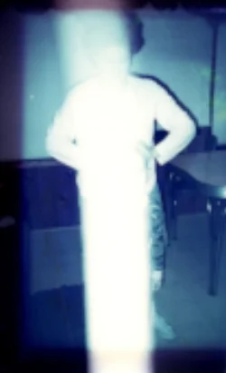 Untouched photo of Constance giving Reiki to her nephew. Note the column of white light energy flowing through.