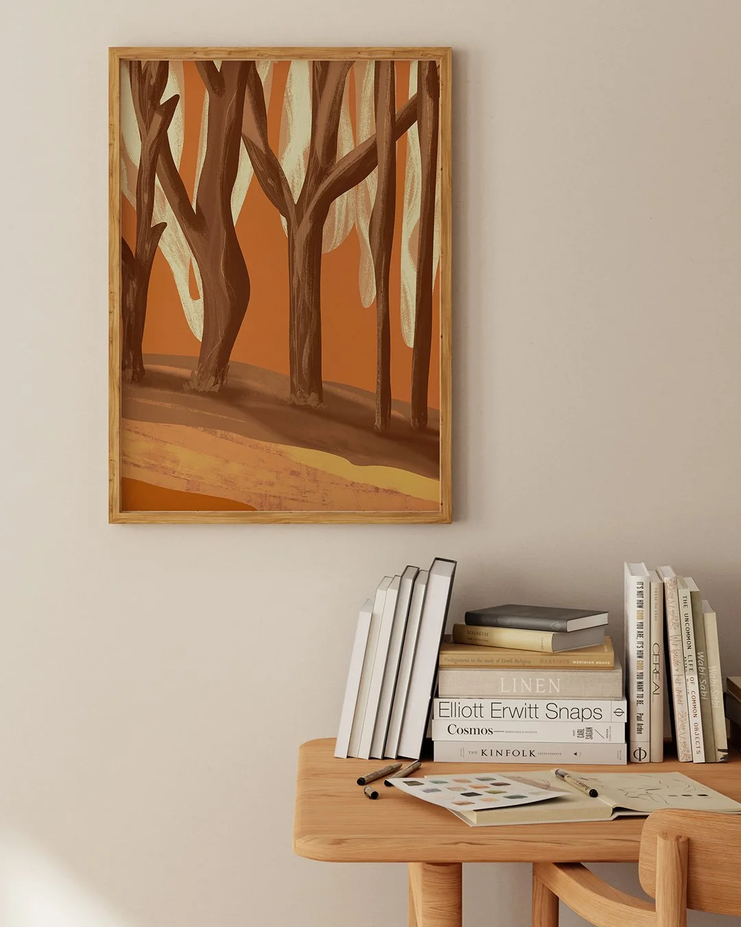 Long Light art print by Very Strange, framed above a wooden desk with books and drawing materials.
