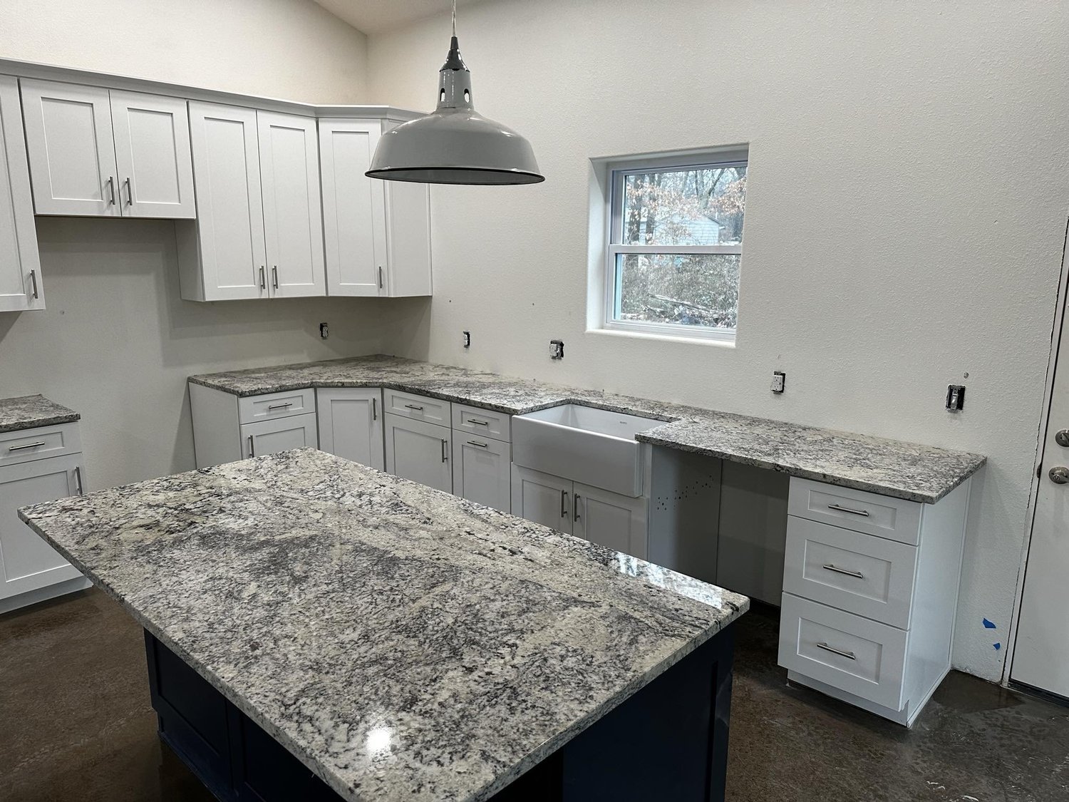 White quartz island with matching countertop and built-in desk area