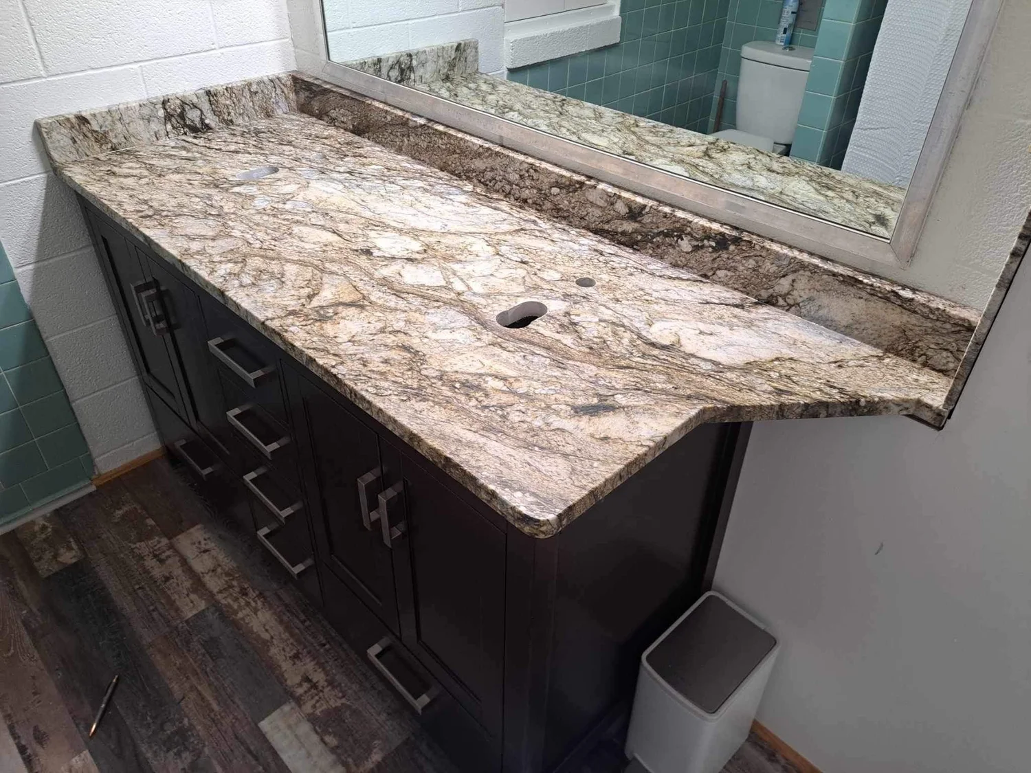 Granite vanity top with a natural live edge in a wood-floored bathroom