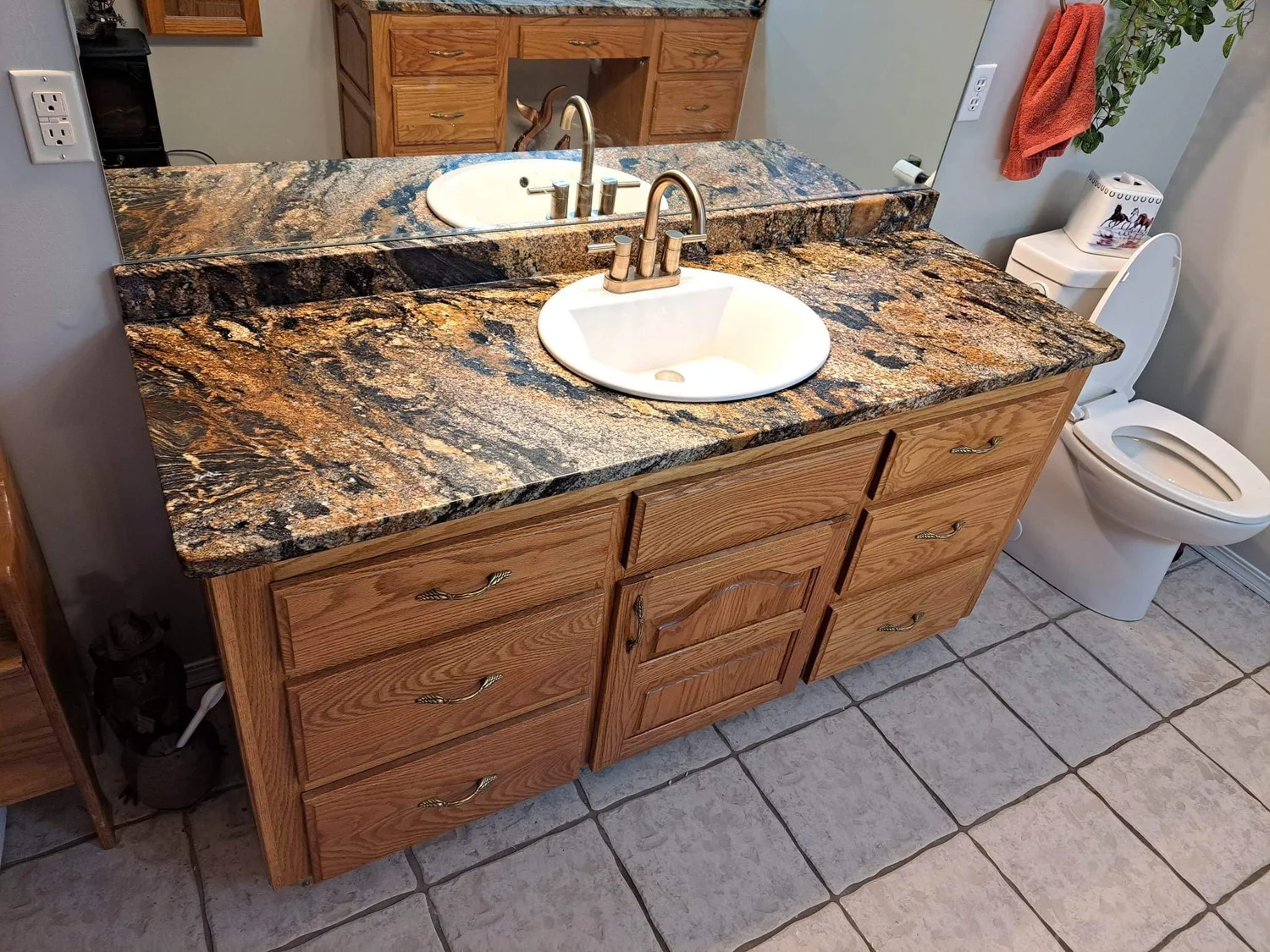 Gold-toned granite vanity top with an oval undermount sink