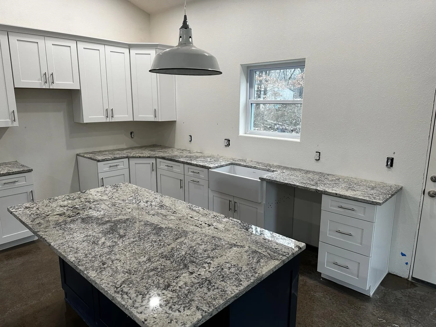 Granite island and perimeter countertops in an open-plan kitchen