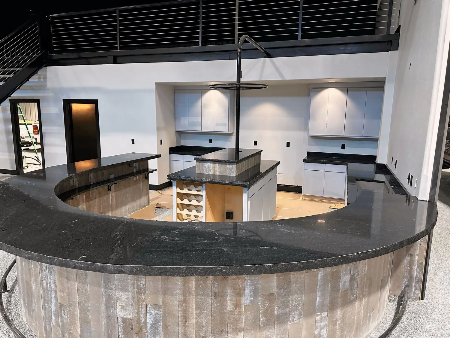 Curved outdoor stone bar top with pendant lighting and bar seating