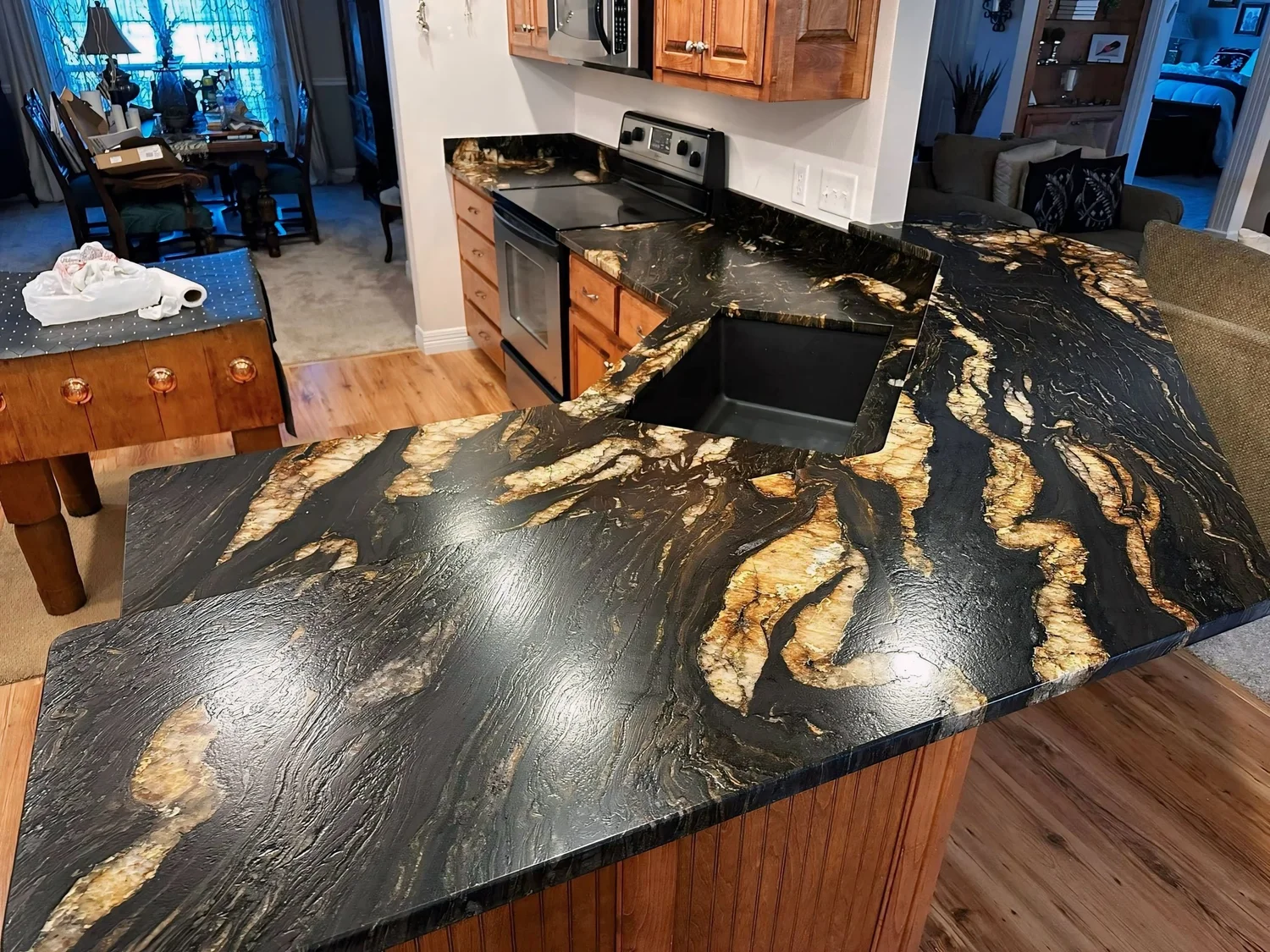 Black granite table top with sweeping gold veining and polished edges