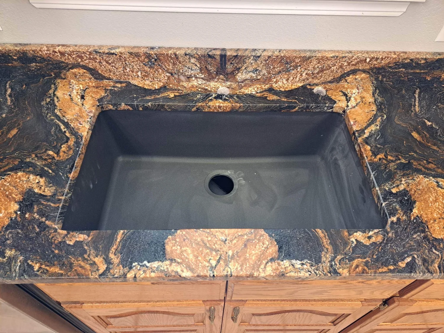 Close-up of an undermount sink set into gold-veined granite