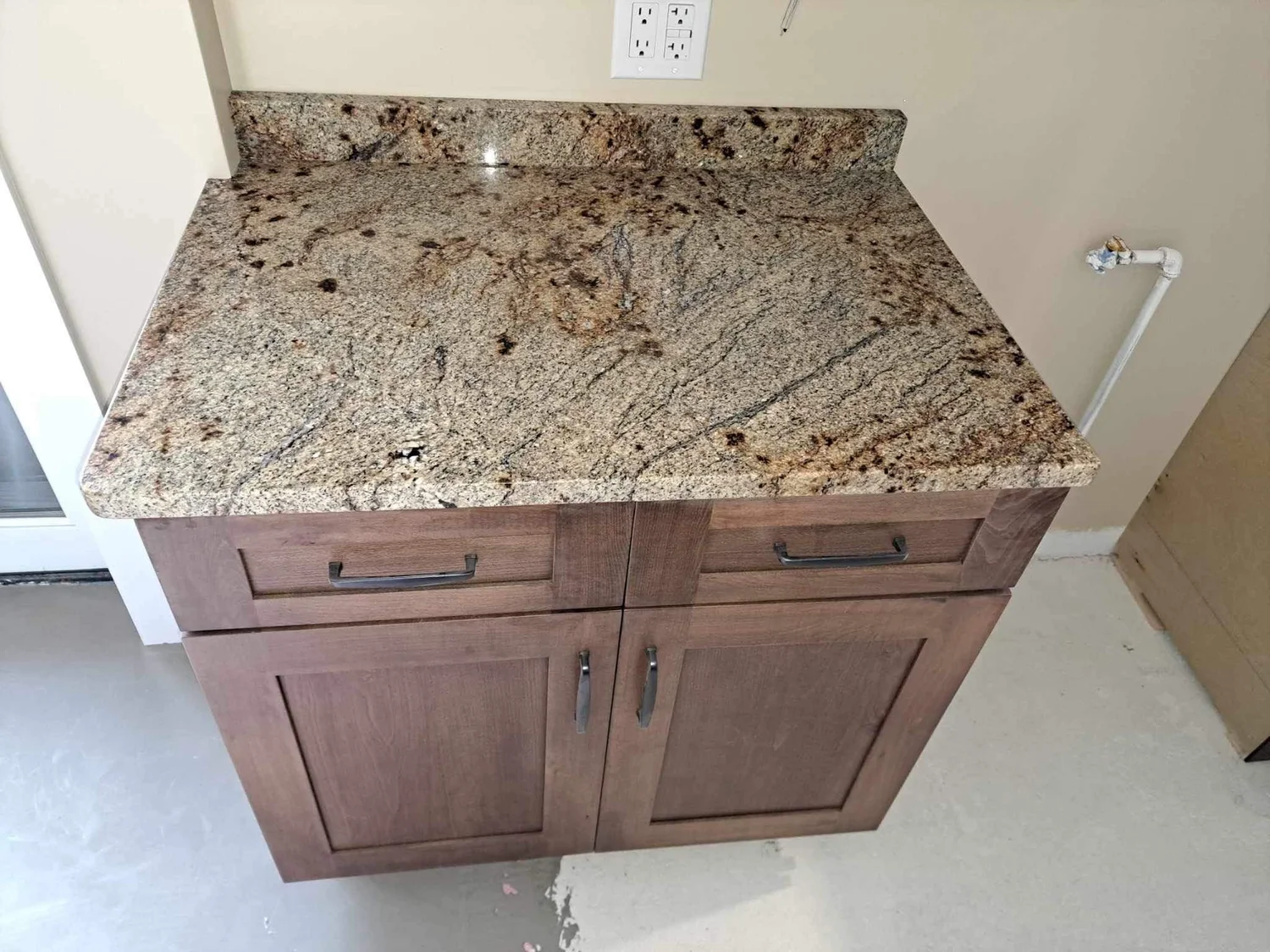 Speckled granite vanity top with an undermount sink and oak cabinet