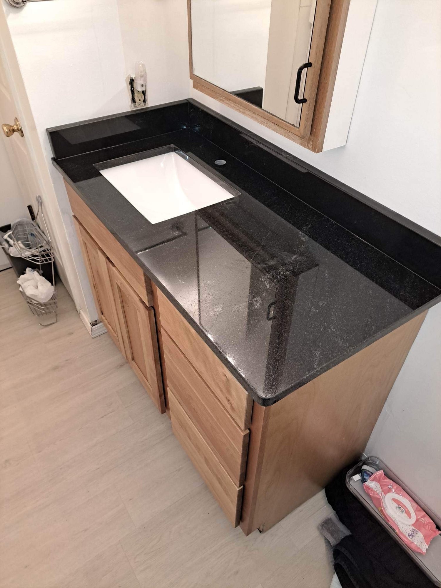 Dark granite vanity top with an undermount sink in a remodeled bath