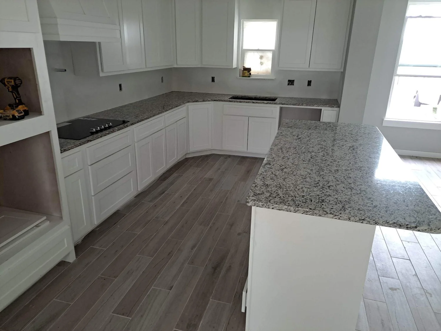Granite countertops turning a corner in a light gray kitchen