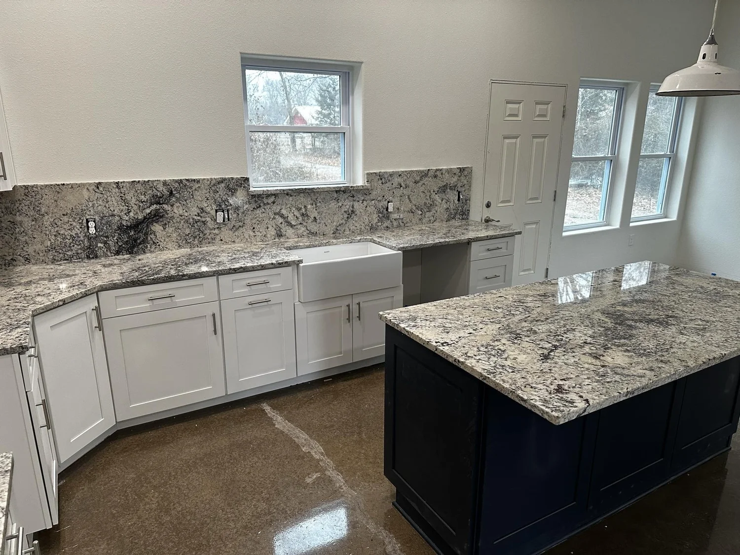 Granite countertops and island installed in a white shaker cabinet kitchen