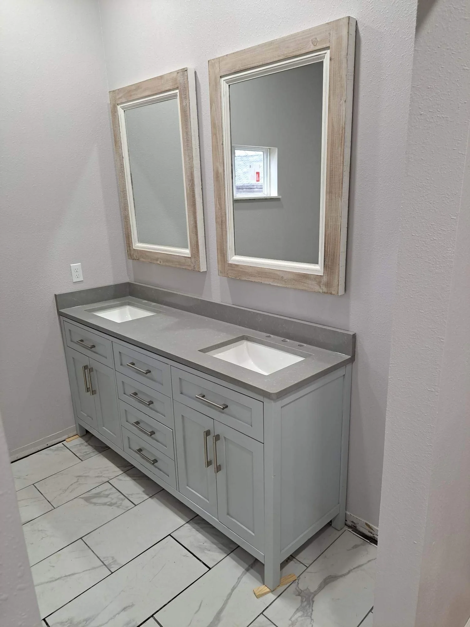 Gray double vanity with stone top and framed mirrors