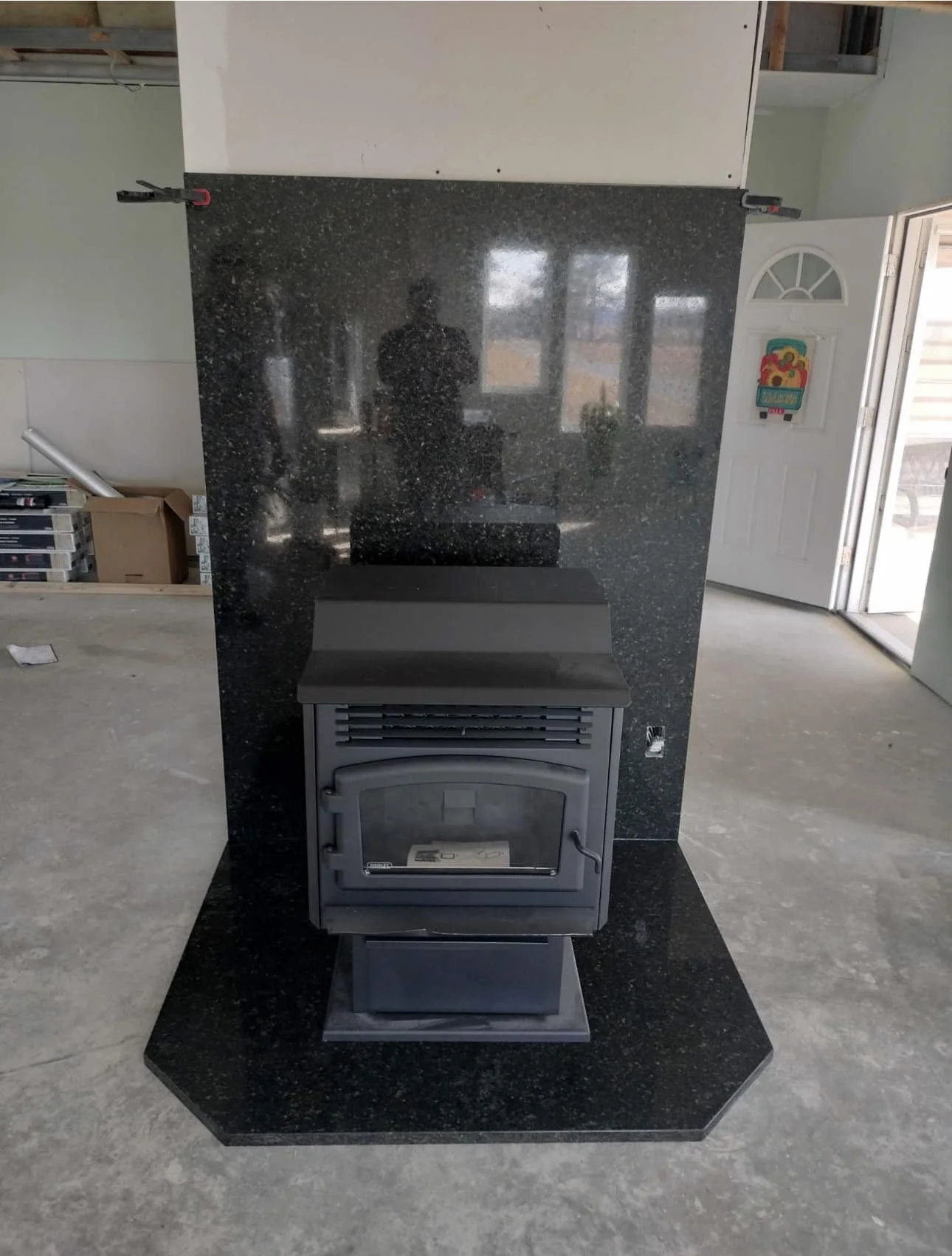 Black granite hearth pad beneath a freestanding wood stove
