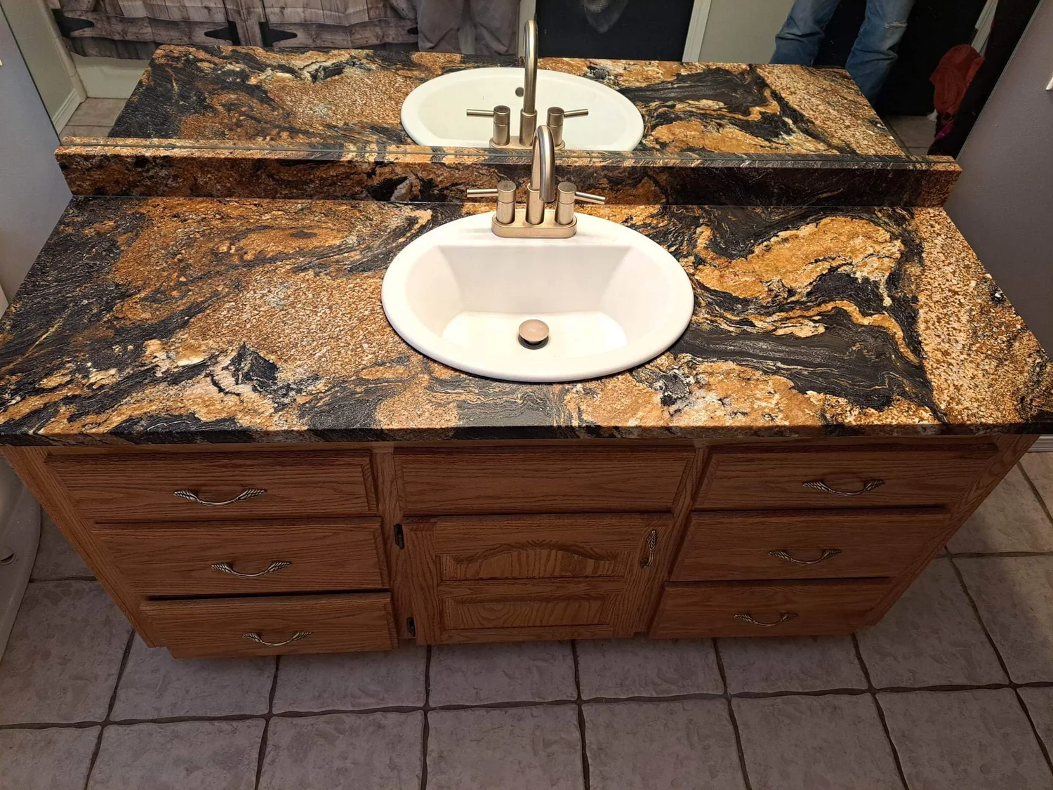 Gold and black granite vanity top with an oval undermount sink
