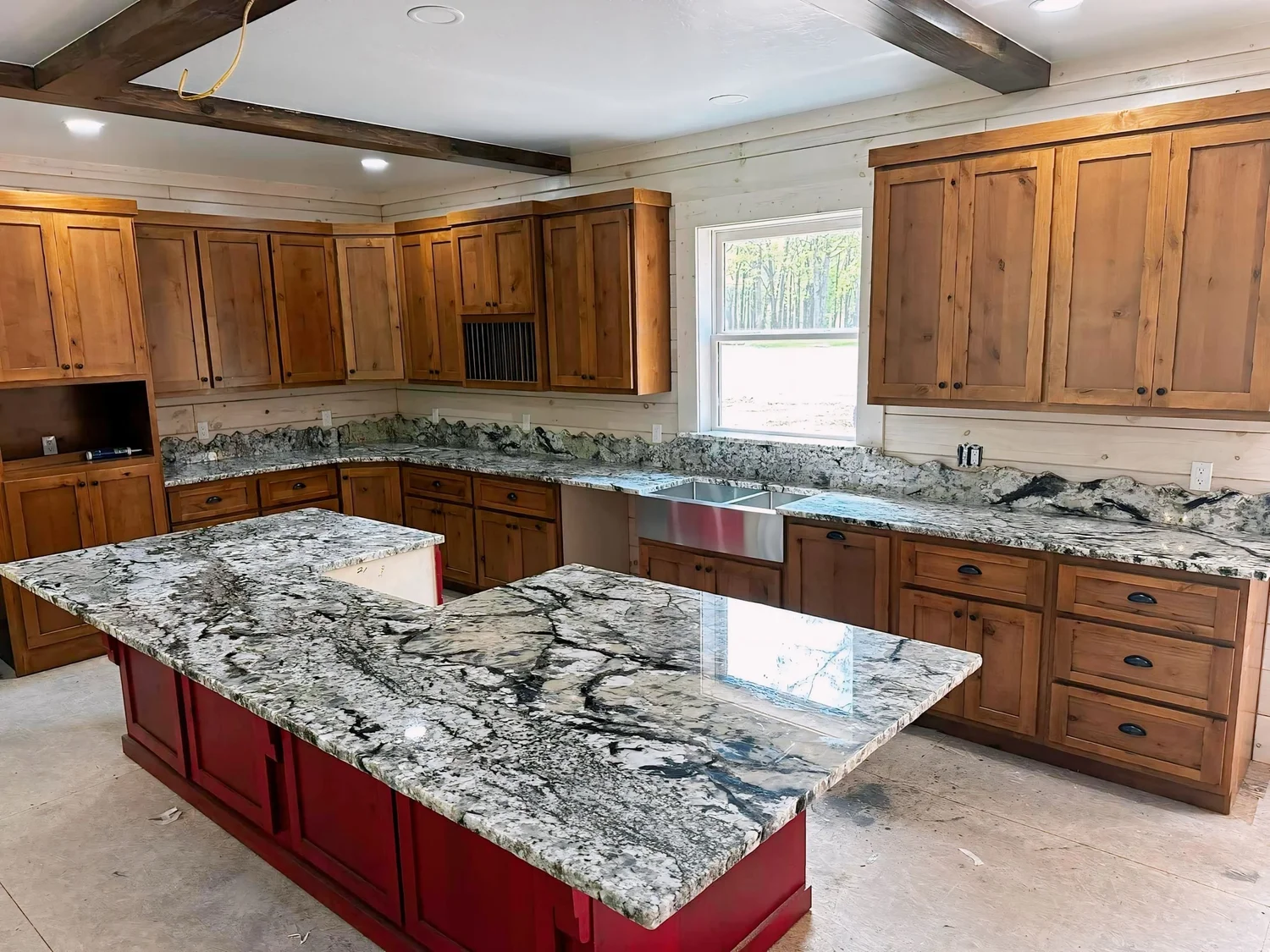Granite countertops with a contrasting painted island in a wood kitchen