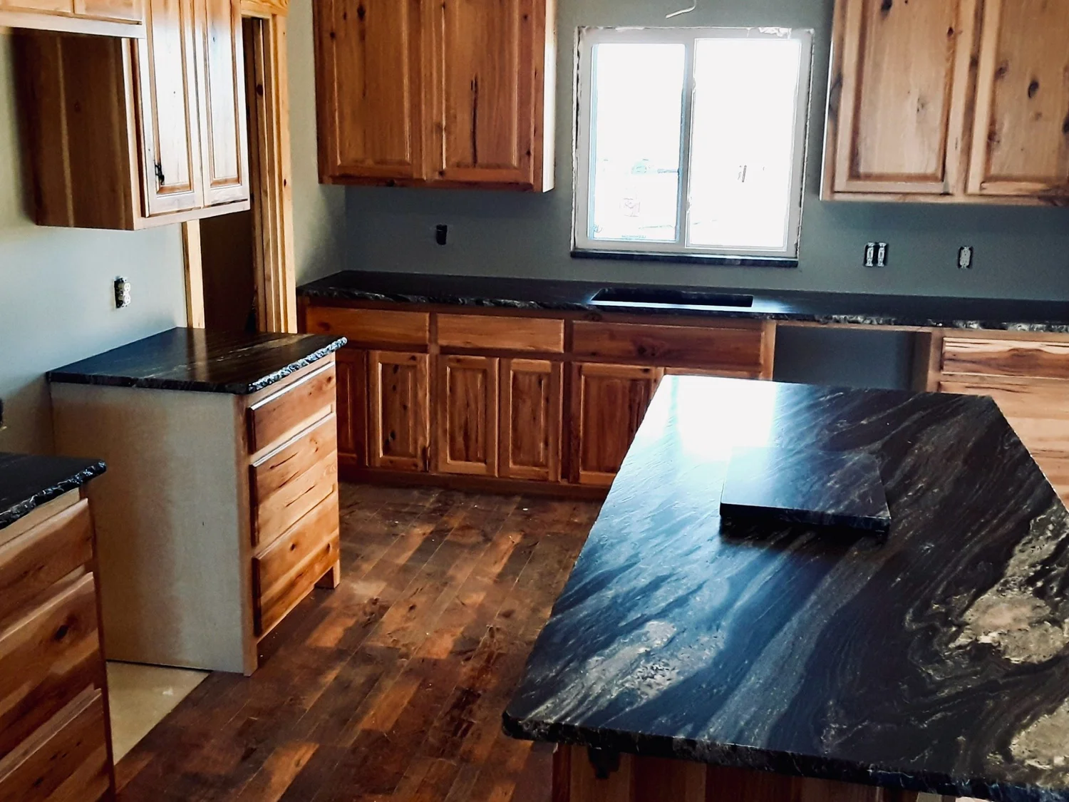 Black granite island with heavy gold veining and a raised bar
