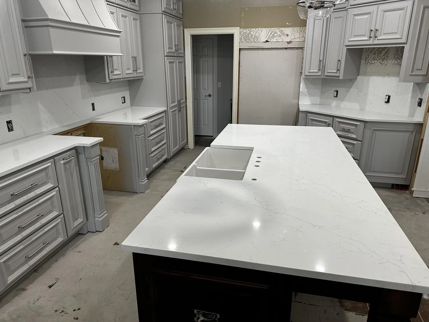Quartz kitchen island with a seating overhang in a bright remodeled kitchen