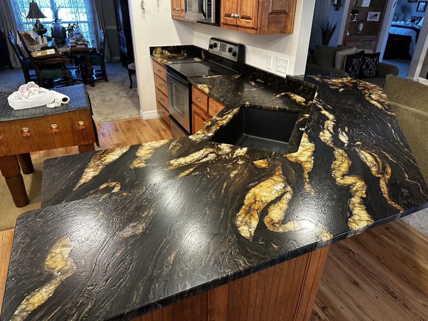 Dramatic black granite island with gold veining polished to a high shine